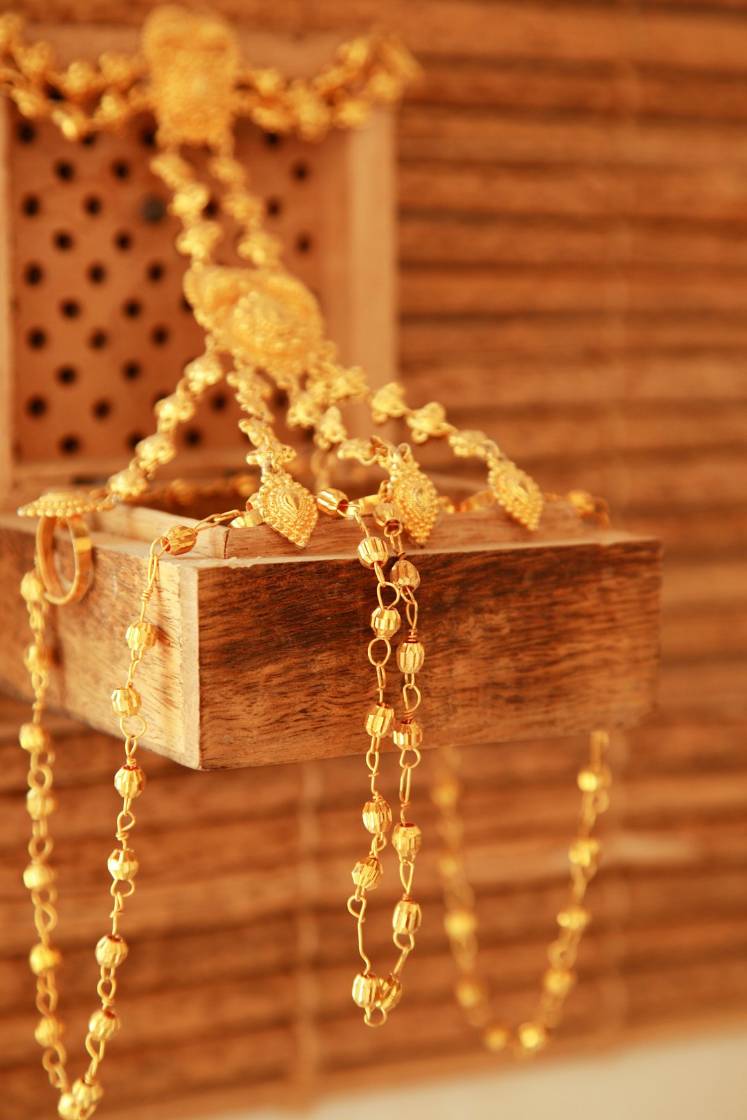 Como saber se o ouro é verdadeiro antes de vender ou comprar Colar de ouro apoiado em caixa de madeira, exemplo para saber se o ouro é verdadeiro
